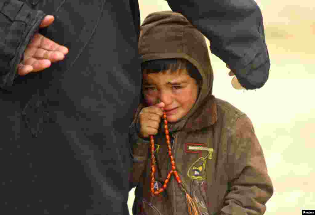 13일 시리아 이들리시에서 원조를 기다리는 가족. 아빠 옆에서 울고 있는 소년.