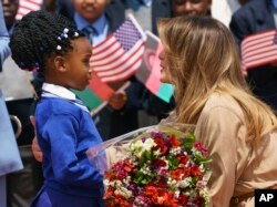 Melania Trump es saludada por una niña a su llegada al Aeropuerto Internacional de Lilongwe, Malawi, el juves, 4 de octubre de 2018.2018.