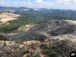 FILE - Coal trucks and heavy equipment are seen on the Middle Ridge surface coal mine in southern West Virginia, Sept. 26, 2017.