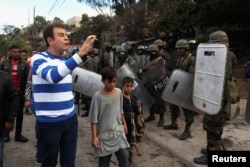 Opposition candidate Salvador Nasralla takes video of soldiers during a protest against the re-election of Honduran President Juan Orlando Hernandez in Tegucigalpa, Honduras, Jan. 20, 2018.