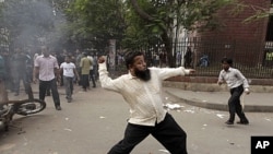 A demonstrator throws a brick at police during clashes between police and Bangladesh Nationalist Party (BNP) protesters in front of the Dhaka Judge Court in Dhaka, December 4, 2011.