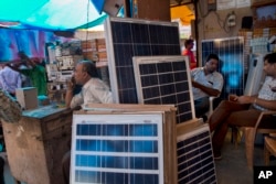 FILE - Solar panels are displayed for sale at a market in New Delhi, India, Oct. 1, 2015. India plans a fivefold boost in renewable energy capacity in the next five years to 175 gigawatts, including solar power, wind, biomass and small hydropower dams.