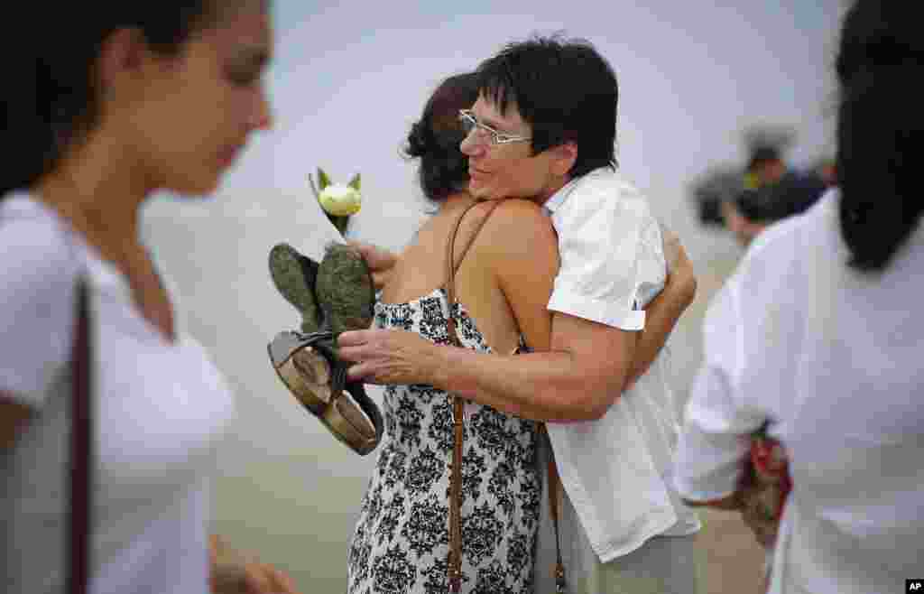 Relatives of the Asian tsunami's victims comfort each other during a commemoration for Germans, Austrians and Swiss killed in Khao Lak, Thailand, Dec. 26, 2014. 