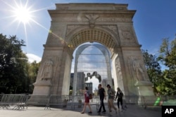 People walk by "Arch," by Chinese activist artist Ai Weiwei, inside the Washington Square Arch, in New York's Greenwich Village, part of his "Good Fences Make Good Neighbors" installations, Oct. 10, 2017.