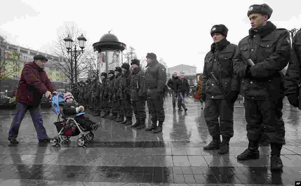 2011年12月4号,俄罗斯警察守卫在一个广场入口处,防止民众抗议者进入。背景是莫斯科大剧院。 (AP)