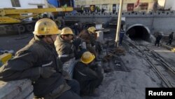 Rescuers sit next to the entrance of a coal mine after a flooding incident in Datong, Shanxi province, China, April 20, 2015. 