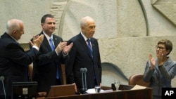 From left: Newly sworn-in Israeli President Reuven Rivlin and Parliament Speaker Yuli Edelstein applaud outgoing President Shimon Peres during a ceremony at the Knesset, in Jerusalem, July 24, 2014. 