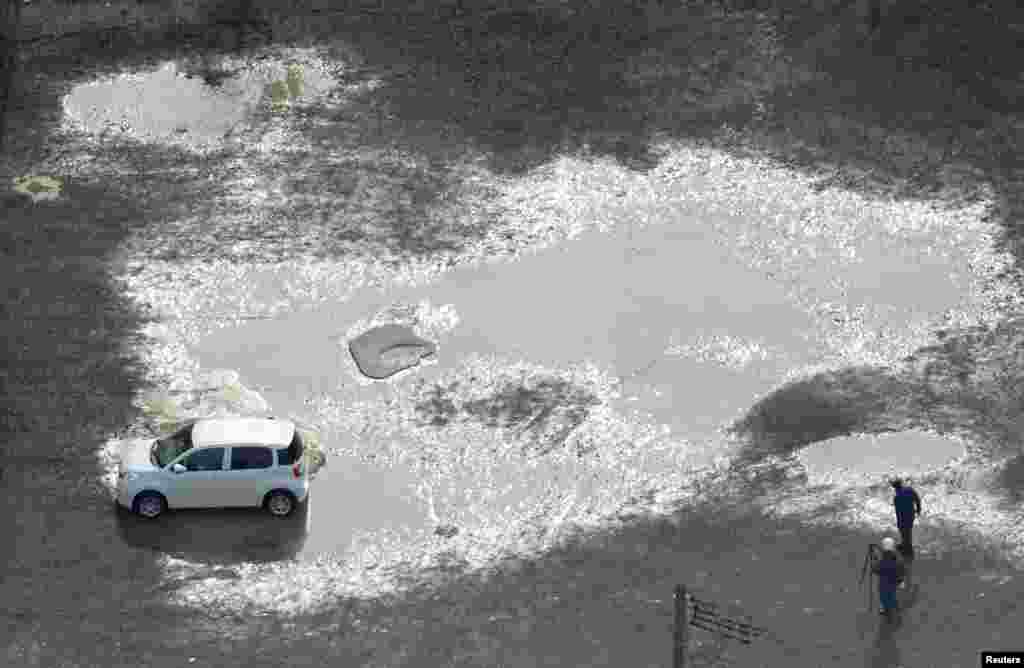 A car is seen trapped at the soil liquefaction caused by an earthquake near Tsuruoka station in Tsuruoka, Yamagata prefecture, Japan, in this photo taken by Kyodo.