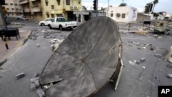 Cars drive past barricades set up by Bahraini demonstrators at a Shiite neighborhood in Manama on March 17, 2011