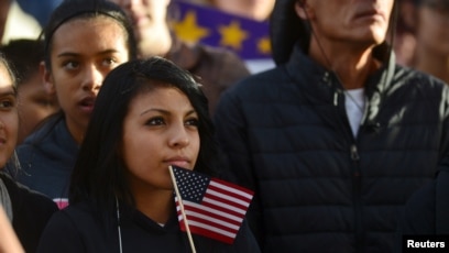 Una joven hispana con una bandera de Estados Unidos en una fotografía de archivo.