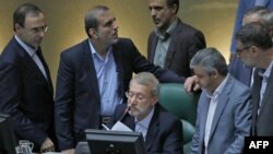 FILE - Iranian Parliament Speaker Ali Larijani (C), surrounded by lawmakers, speaks during a session in the capital Tehran, Aug. 28, 2018.