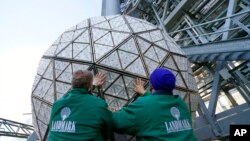 FILE - Workers from Landmark Signs secure a panel of Waterford crystal triangles after installing it on the Times Square New Year's Eve ball, in New York, Dec. 27, 2020.