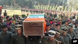 Indian Border Security Force officers carry the coffin of a colleague killed Wednesday in an India-Pakistan cross-border firing, in Jammu, India, Jan. 1, 2015. 