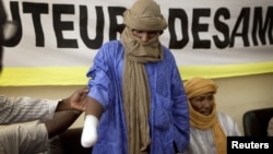 A victim of forced hand amputation by al-Qaida-linked Islamist group Movement for Unity and Jihad under Sharia law as punishment for stealing livestock, Alhader Ag Mahamoud, 30, attends a news conference organized by Amnesty International in Bamako, Mali,