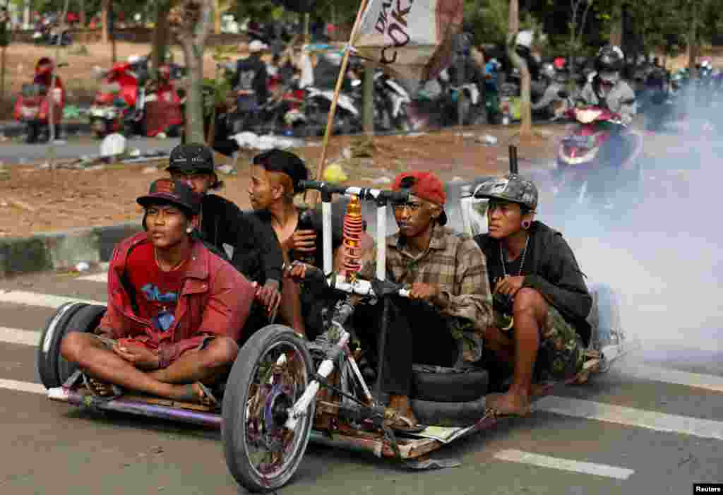 Extreme Vespa enthusiasts drive their vehicle near the site of a weekend festival for extreme Vespas in Semarang, Central Java, Indonesia.