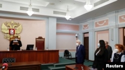 A judge of the Russian Supreme Court delivers the verdict during a hearing to consider the closure of the human rights group International Memorial in Moscow, Dec. 28, 2021.