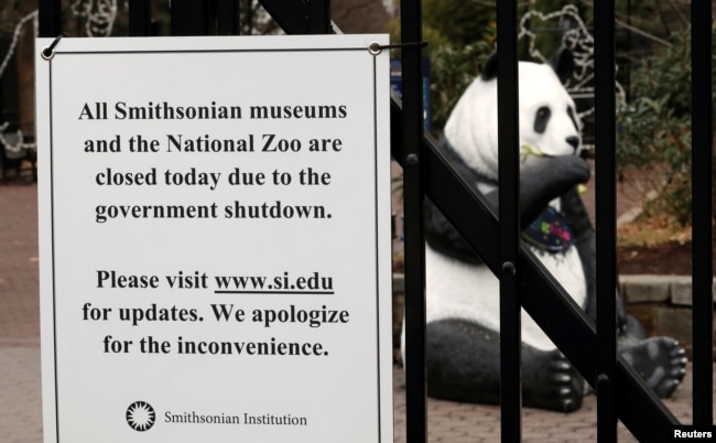 The figure of a panda is seen behind a sign telling the public that the National Zoo is closed due to the partial government shutdown in Washington, Jan. 2, 2019.