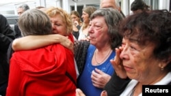 Relatives of former workers at Ford Motor Co. local plant and ex-political prisoners react after two former Ford executives were convicted during the trail, in Buenos Aires, Argentina, Dec. 11, 2018.