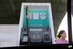 In this April 26, 2017, photo, a gas attendant waits by a pump at a gas station in Pyongyang, North Korea.