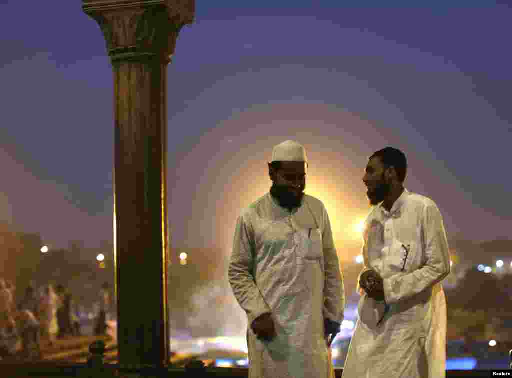 Muslims relax outdoors after having their Iftar, or breaking of the fast meal, on the first day of the holy month of Ramadan in India, at the Grand Mosque, in the old quarters of Delhi, India, June 30, 2014.