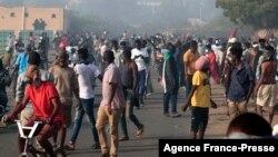 Pasukan keamanan Sudan menembakkan gas air mata ke arah demonstran di Jalan al-Qasr, Khartoum, dalam aksi protes hari Minggu (2/1). 