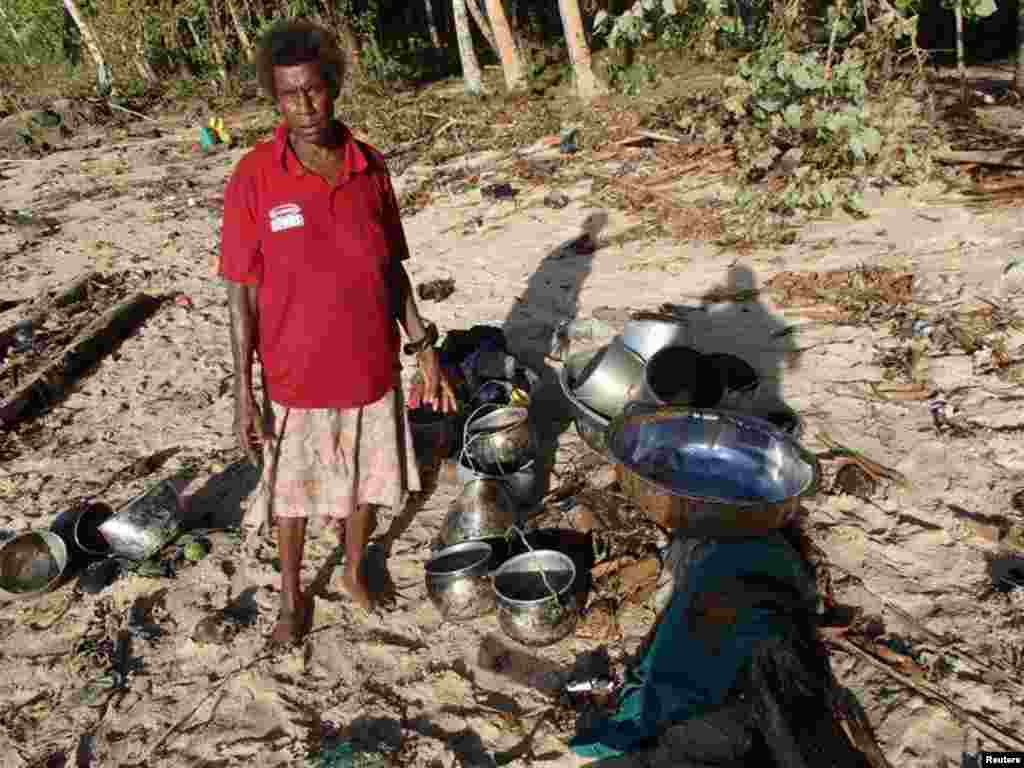 A villager collects belongings after a tsunami hit Venga village on Solomon Islands, Feb. 7, 2013. (World Vision)