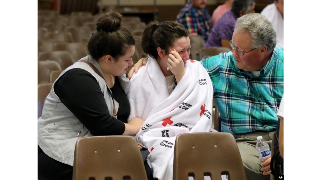 Hannah Miles, center, is reunited with her sister Hailey Miles, left, and father Gary Miles, right, after a shooting at Umpqua Community College in Roseburg, Oregon, Oct. 1, 2015.