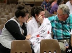 Hannah Miles, center, is reunited with her sister Hailey Miles, left, and father Gary Miles, right, after a shooting at Umpqua Community College in Roseburg, Oregon, Oct. 1, 2015.