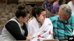 Hannah Miles, center, is reunited with her sister Hailey Miles, left, and father Gary Miles, right, after a shooting at Umpqua Community College in Roseburg, Oregon, Oct. 1, 2015.
