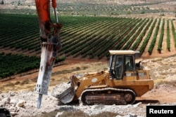 A man operates a bulldozer on a field as work begins on the construction of Amichai, a new settlement which will house some 300 Jewish settlers evicted in February from the illegal West Bank settlement of Amona, in the West Bank, June 20, 2017.