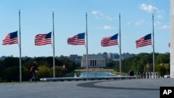 American flags around the Washington Monument are lowered to half-staff in honor of Colin Powell, former Joint Chiefs chairman and secretary of state, Oct. 18, 2021. Powell died from COVID-19 complications.