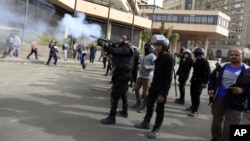 Một sĩ quan cảnh sát chống bạo động Ai Cập bắn hơi cay vào người biểu tình trong cuộc đụng độ gần Quảng trường Tahrir, Cairo, ngày 27/1/2013.