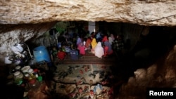 Internally displaced children attend a class inside a cave in the rebel-controlled village of Tramla, in Idlib province, Syria, March 27, 2016. 