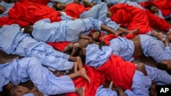 FILE - In this Friday Jan. 13, 2017 photo, Idris 3, from Mali, center, sleeps next to his mother Aicha Keita, right, on the deck of the 'Golfo Azzurro' vessel after being rescued from the Mediterranean sea, about 20 miles north of Ra's Tajura, Libya. 