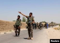 FILE - An Afghan National Army (ANA) soldier gestures as they arrive in Nad Ali district of Helmand province, southern Afghanistan, Aug. 10, 2016.