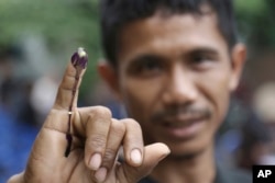 An Indonesian man shows his ink-stained finger after voting in Jakarta, Indonesia, Feb. 15, 2017.