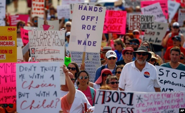 Protesters for women's rights march to the Alabama Capitol to protest a law passed last week making abortion a felony in nearly all cases with no exceptions for cases of rape or incest, May 19, 2019, in Montgomery, Ala.