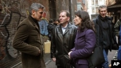 Actor George Clooney, left, talks to Katherine Oliver, center, commissioner of the Mayor's Office of Film, Theatre and Broadcasting, and John Battista, second from left, the deputy commissioner, on the set of the film "Michael Clayton" in this Feb. 15, 20
