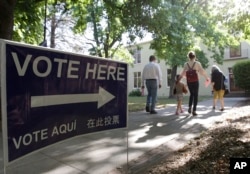 FILE - Voters walk to a precinct place at the Sierra 2 Center for the Arts and Community to cast their ballots, June 5, 2018, in Sacramento, Calif.