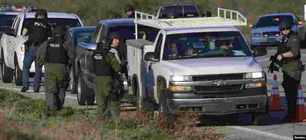 SWAT officers search cars during the manhunt for former Los Angeles police officer Christopher Dorner, in Yucaipa, California, Feb. 12, 2013. 