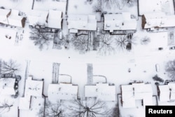 Snow covers a neighborhood during a winter storm in Dayton, Ohio, Jan. 17, 2022.
