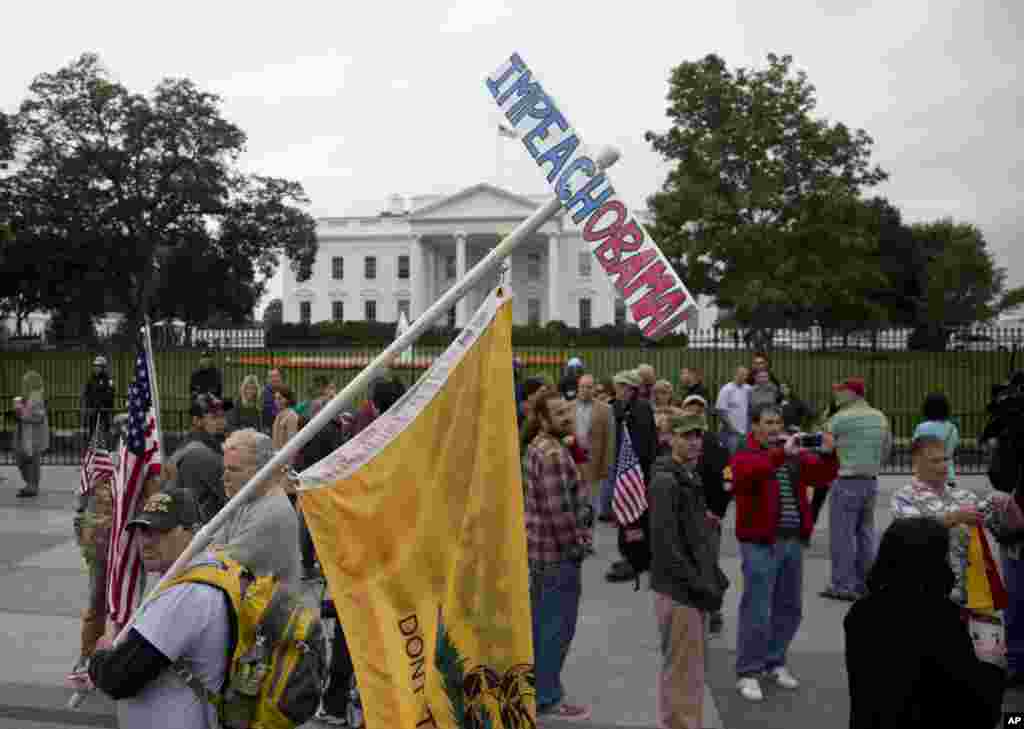 A man carries an "Impeach Obama" sign while protesting outside the White House in Washington, Oct. 13, 2013.