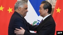 Dominican Republic Foreign Minister Miguel Vargas (L) embraces China's Foreign Minister Wang Yi after a signing ceremony where they formally established relations, in Beijing, May 1, 2018. 
