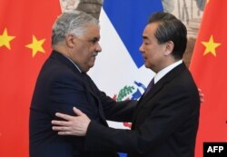 Dominican Republic Foreign Minister Miguel Vargas (L) embraces China's Foreign Minister Wang Yi after a signing ceremony where they formally established relations, in Beijing, May 1, 2018.