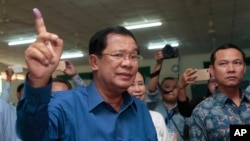 Cambodian Prime Minister Hun Sen of the Cambodian People's Party shows off his inked finger after voting in local elections at Takhmua polling station in Kandal province, southeast of Phnom Penh, Cambodia, June 4, 2017.