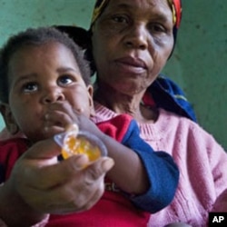 A child with HIV is given medication by a care-giver in Durban, South Africa Tuesday