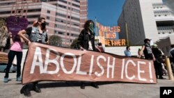 Archivo. Manifestantes despliegan un cartel que dice "Eliminen ICE" durante una protesta frente a la instalación del Servicio de Inmigración y Aduanas en Los Ángeles, California, el 2 de julio de 2018.