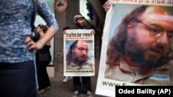 Israeli protesters hold posters demanding the release of Jonathan Pollard, a Jewish American who was jailed for life in 1987 on charges of spying on the United States, as they stand outside the U.S. embassy in Tel Aviv, Israel, Sunday, June 19, 2011.