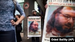 Israeli protesters hold posters demanding the release of Jonathan Pollard, a Jewish American who was jailed for life in 1987 on charges of spying on the United States, as they stand outside the U.S. embassy, Tel Aviv, Israel, June 19, 2011.
