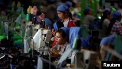 FILE: Women work on the production line at Complete Honour Footwear Industrial, a footwear factory owned by a Taiwan company, in Kampong Speu, Cambodia, July 4, 2018. REUTERS/Ann Wang 